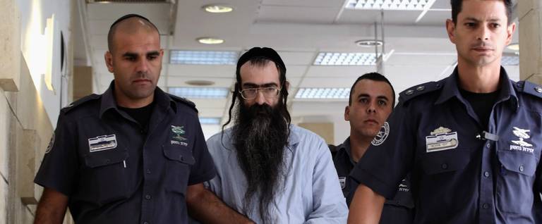 Yishai Shlissel (C) is escorted by policemen into a Jerusalem district courtroom, June 26, 2016. 