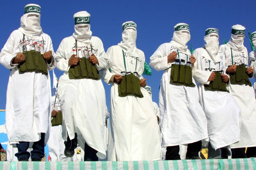 Masked Hamas militants dressed as suicide bombers march in a rally in Khan Younis on Dec. 13, 2002. More than 30,000 people gathered at the camp to mark the 15th anniversary of the founding of Hamas.