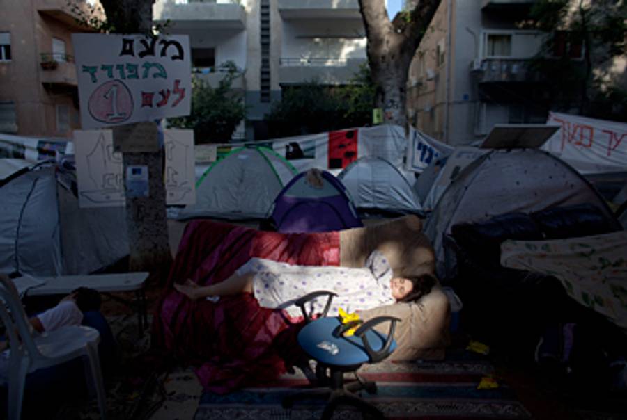 A protester asleep amid the protest tents in Tel Aviv earlier this month.(Uriel Sinai/Getty Images)