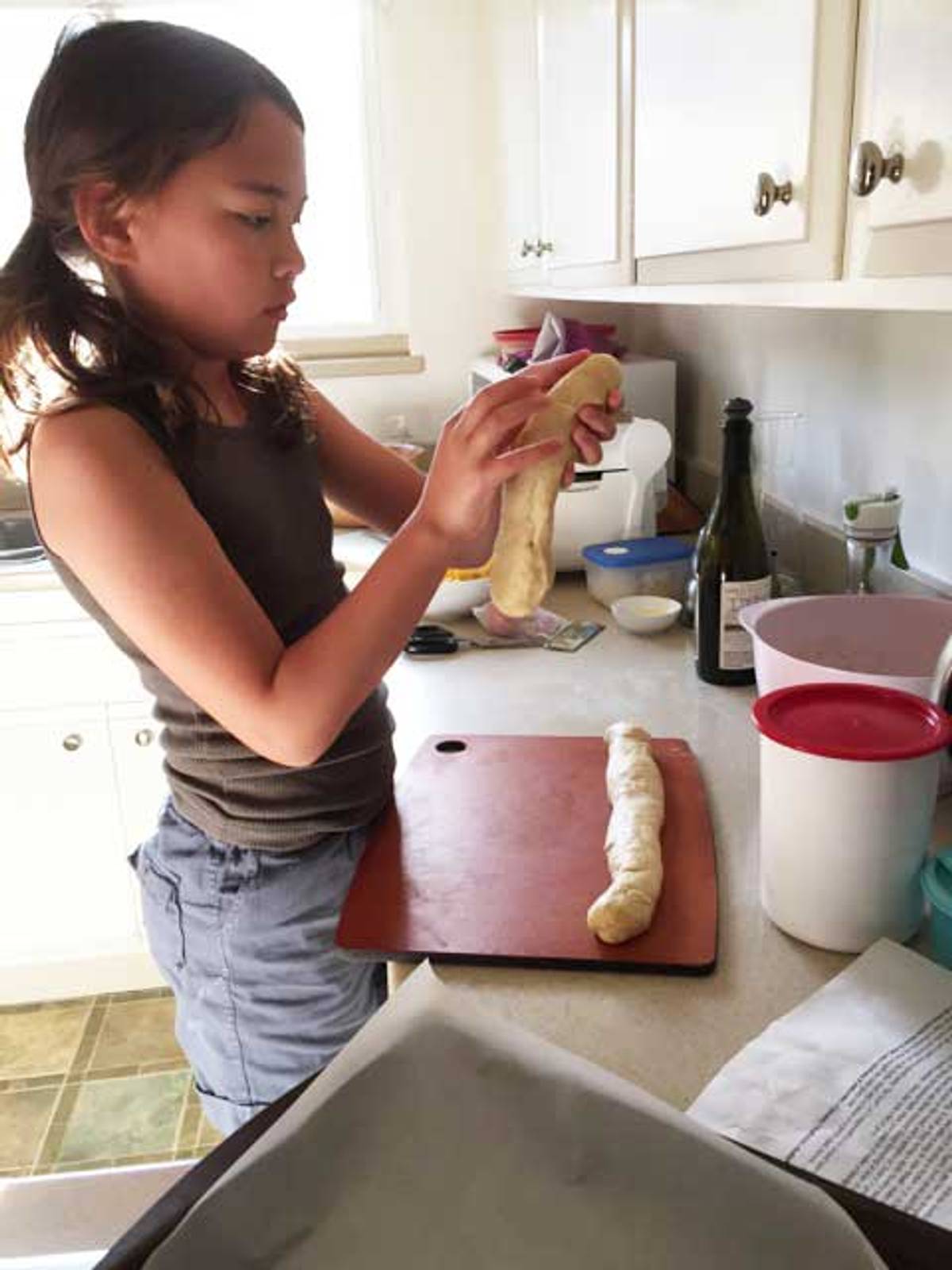The author baking challah, aged 9