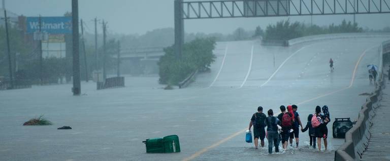 Evacuation residents from the Meyerland area walk onto an I-610 overpass for further help during the aftermath of Hurricane Harvey August 27, 2017 in Houston, Texas.