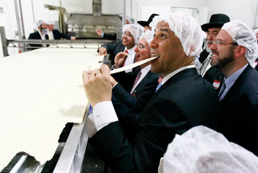 Newark Mayor Cory Booker eats a piece of a large matzo that was baked during the grand opening of the headquarters for the Manischewitz company, June 14, 2011 in Newark, N.J.