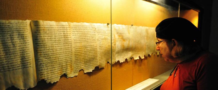Woman looks at the Dead Sea Scrolls on display at the caves of Qumran.