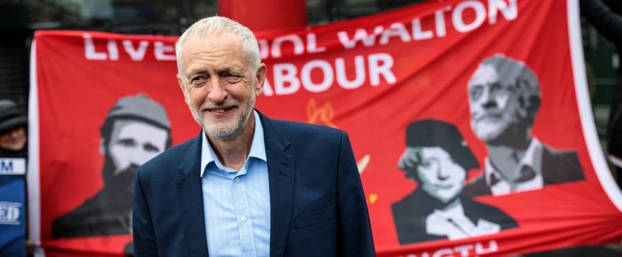 Labour leader Jeremy Corbyn poses for photos in front of a banner at Liverpool Lime Street Station as he tours the North of England by rail on Sept. 3, 2018, in Liverpool, England.