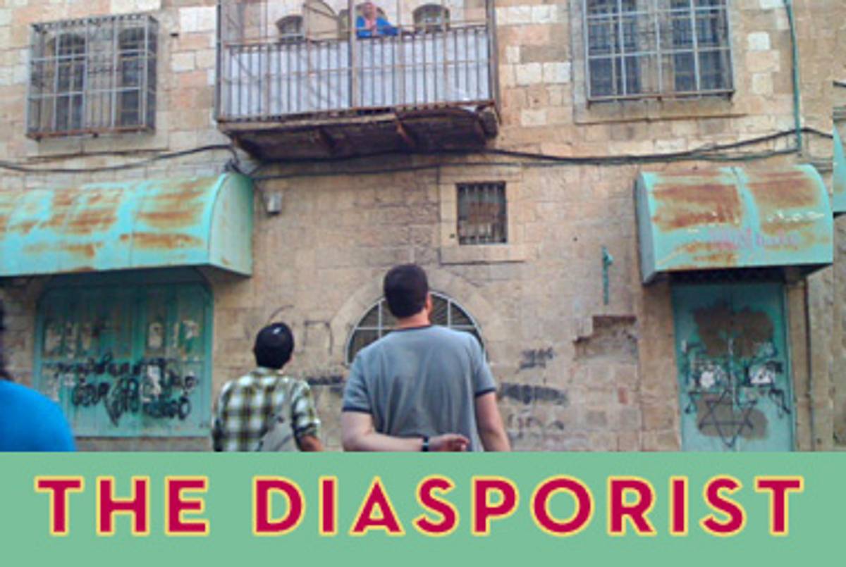 Mikhael Manekin, at left, in the Old City of Hebron. The balcony belongs to an Arab resident and is surrounded by bars to protect her from stone-throwing settlers.(Michelle Goldberg)