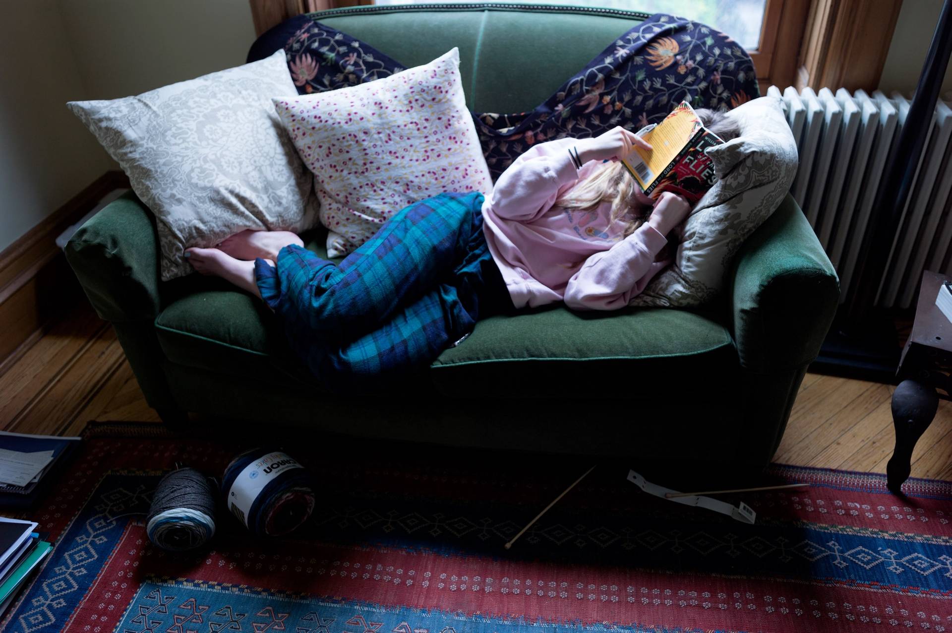 A teenager reads a school English assignment at home after her Brooklyn school shut down because of the COVID-19 pandemic, on March 22, 2020