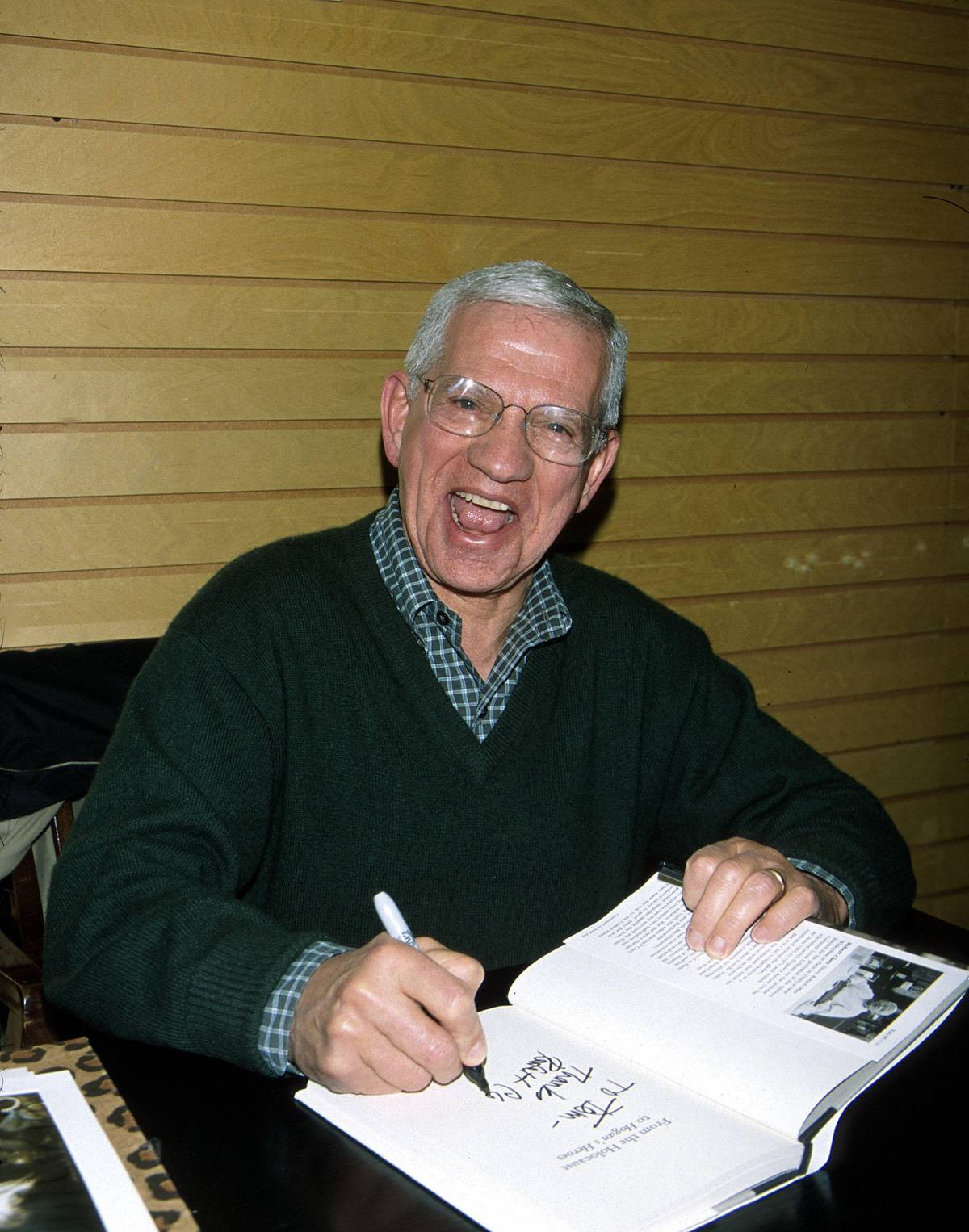 Robert Clary signs a copy of his book 'From the Holocaust to Hogan's Heroes,' at Barnes & Noble, Los Angeles, 2002