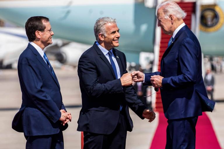 Israeli President Isaac Herzog, at left, and Israeli Prime Minister Yair Lapid, center, receive U.S. President Joe Biden upon landing at Ben-Gurion Airport on July 13, 2022