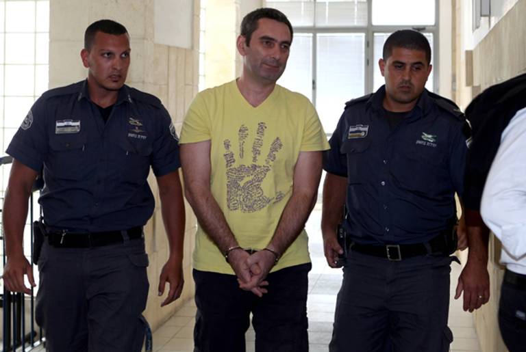 Aleksandar Cvetkovic (C), is brought into the Jerusalem district court on August 1, 2011 to a hearing regarding Israel's state prosecutor request to extradite the Bosnian Serb who obtained Israeli citizenship through his Jewish wife.( GALI TIBBON/AFP/Getty Images)