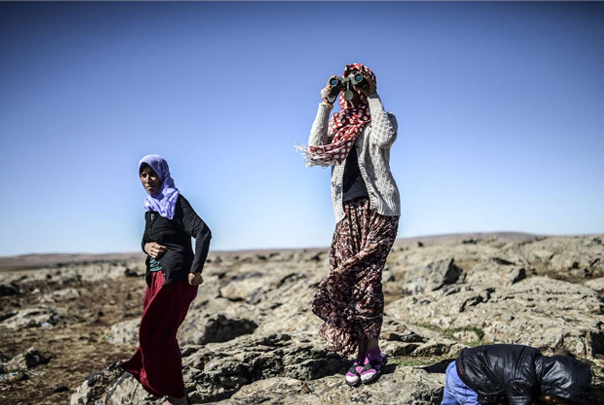 Members of the Syrian Kurdish Altay family in the Turkish Syrian border village of Mursitpinar try to spot their relative, Zamani Suruc, who is fighting ISIS jihadists in the Syrian border town of Kobane, also known as Ain al-Arab, on October 20, 2014. (BULENT KILIC/AFP/Getty Images)