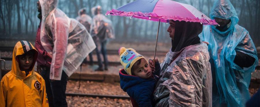 A group of migrants and refugees wait at a train station for a train in southern Serbian town of Presevo on January 6, 2016.