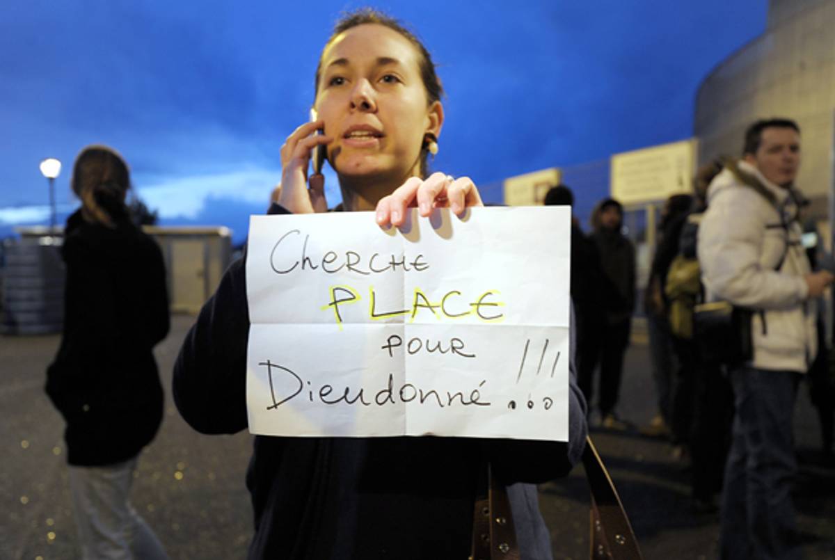 A woman holds a placard reading 'Looking for a ticket for Dieudonne!' prior to the performance of French controversial humorist Dieudonne M'bala M'bala in front of the Zenith on January 9, 2014 in Saint-Herblain, France, as French Interior minister called for Dieudonne's new tour performances to be banned. (JEAN-SEBASTIEN EVRARD/AFP/Getty Images)