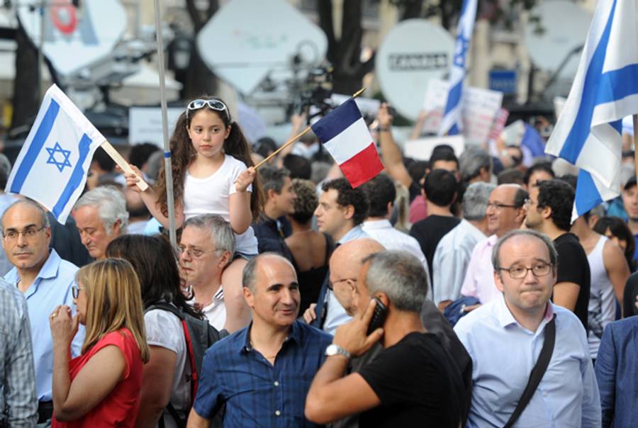 A girl waves an Israel national flag and a French national flag during a pro-Israel demonstration organized by the Representative Council of Jewish Institutions in France (CRIF) outside the Jewish state's embassy on July 31, 2014. (DOMINIQUE FAGET/AFP/Getty Images)