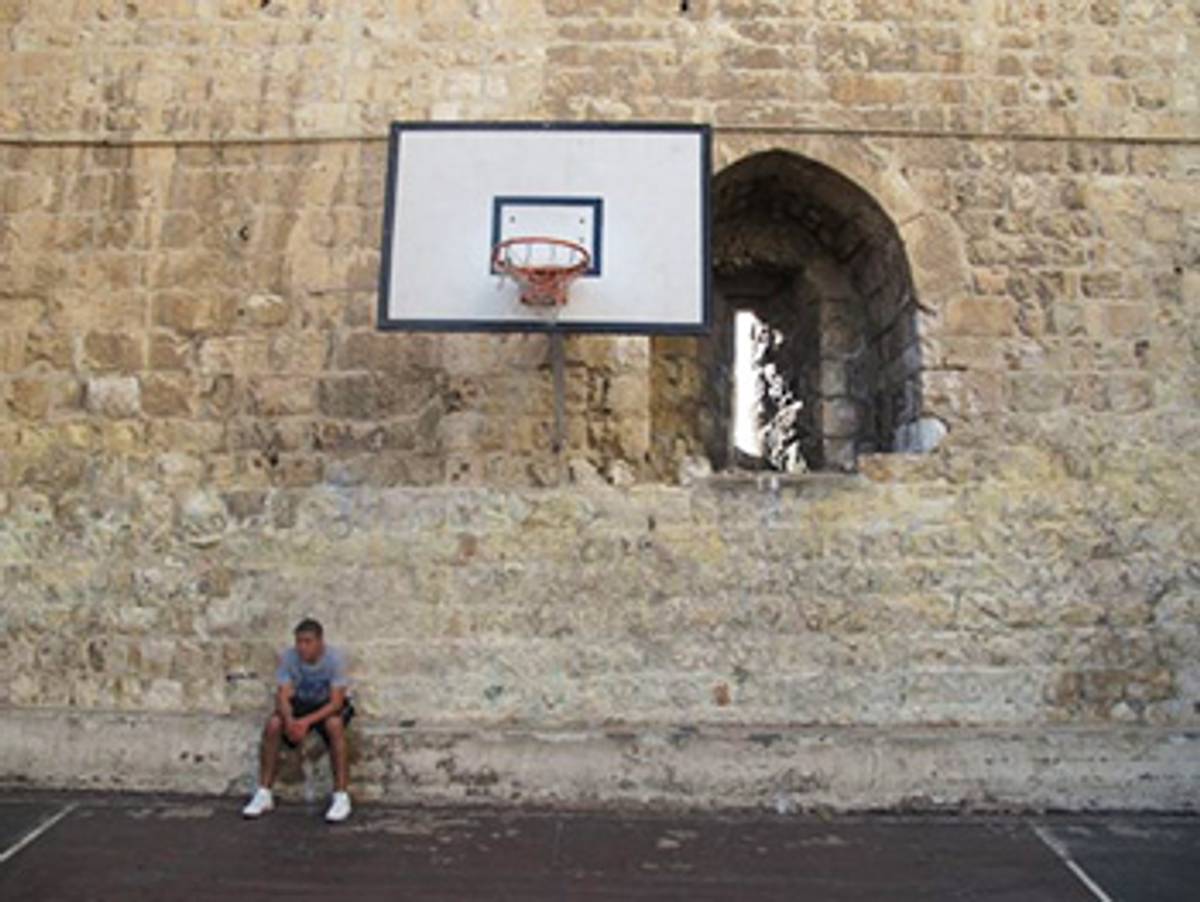 Jamir Khoury, 19, a fan of Issa’s, rests after playing one-on-one against a friend. Issa spent much of his youth practicing on this court, which is located just inside the ancient wall of Jerusalem’s Old City. 