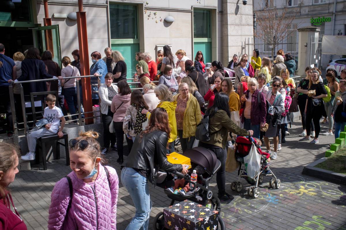 Ukrainian refugees queue outside the Jewish Community Center of Krakow, April 14, 2022
