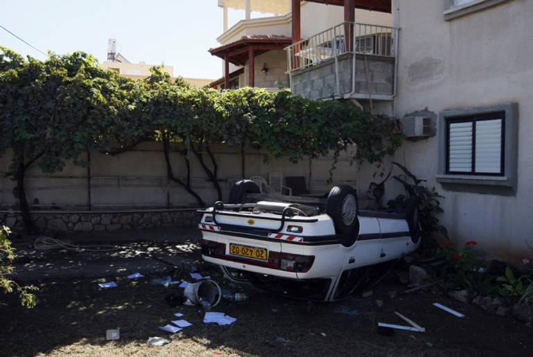 An up-turned car lies in the front garden of a vandalized Arab home in the northern Israeli city of Acre on Oct. 10, 2008, following violent unrest between Israeli Arab and Jewish residents of the mixed city.(David Furst/AFP/Getty Images)