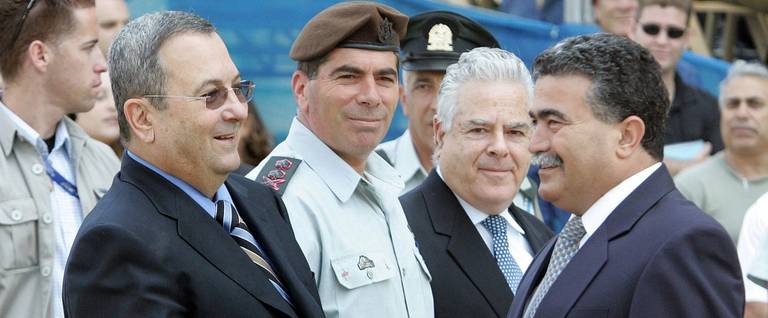 Minister Ehud Barak (wearing sunglasses) shakes hands with outgoing Defense Minister Amir Peretz during the handing-over ceremony at the Defense Ministry in 2007.