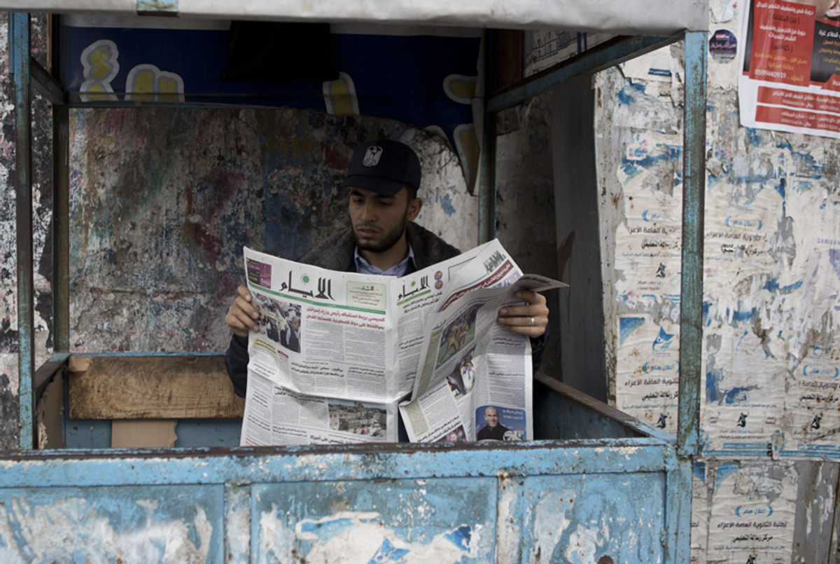 A Palestinian Hamas policeman reads a copy of the Al-Ayyam newspaper in Gaza City, on May 8, 2014. The Palestinian daily, which is edited and printed in the West Bank city of Ramallah, has been allowed by Hamas to be distributed in the Gaza strip for the first time in seven years.(Mohammed Abed/AFP/Getty Images)