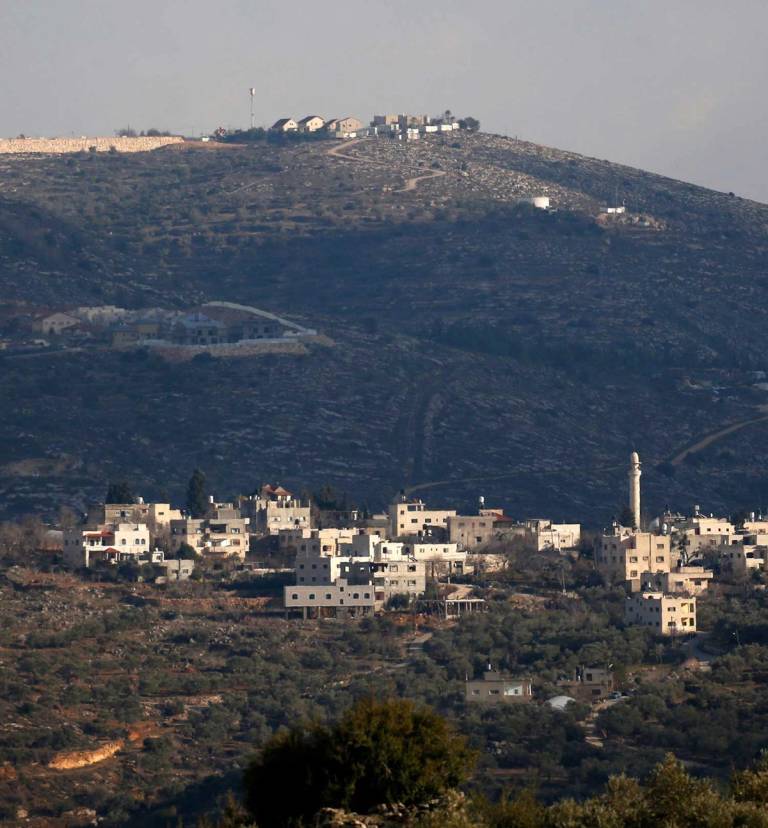 A  2017 photo shows the Palestinian West Bank village of al-Sawiya in the foreground, and the Jewish settlement of Eli in the background