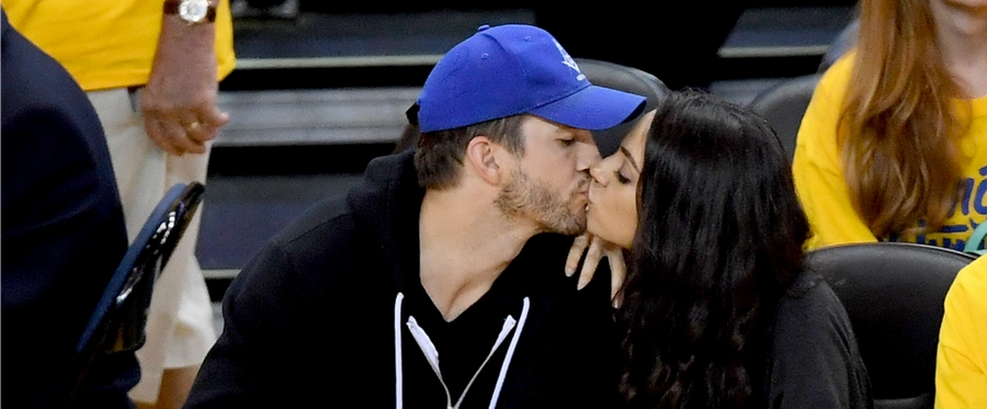 Ashton Kutcher and Mila Kunis share a kiss during Game 2 of the 2016 NBA Finals between the Golden State Warriors and the Cleveland Cavaliers at ORACLE Arena  in Oakland, California, June 5, 2016. 