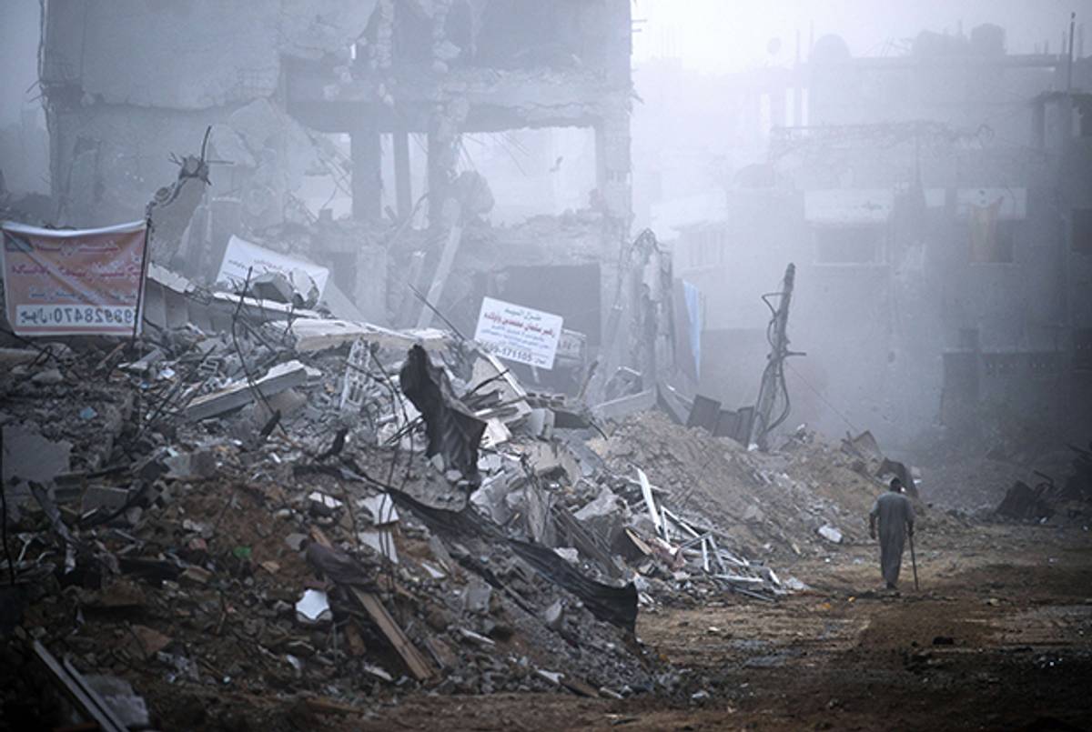 An elderly resident of Gaza City's Shejaiya neighbourhood, which was one of the hardest hit by the fighting between Hamas militants and Israel, walks in a street lined by destroyed homes early on August 27, 2014. (ROBERTO SCHMIDT/AFP/Getty Images)