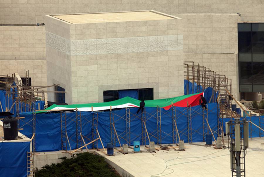 Workers are seen on the scaffolding holding up the tarpaulin obscuring the entrance to the mausoleum of the late Palestinian leader Yasser Arafat, on November 27, 2012, at the Muqataa in the West Bank city of Ramallah.(ABBAS MOMANI/AFP/Getty Images)