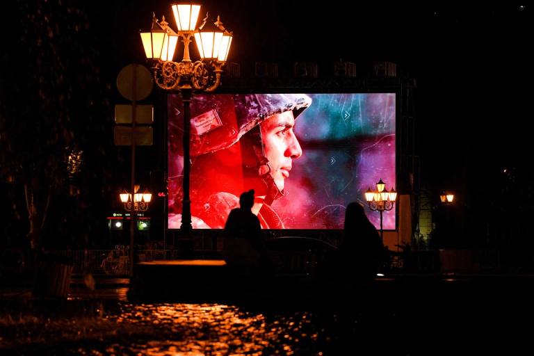 A screen displays patriotic videos in Yerevan during  the Nagorno-Karabakh war, on Oct. 5, 2020