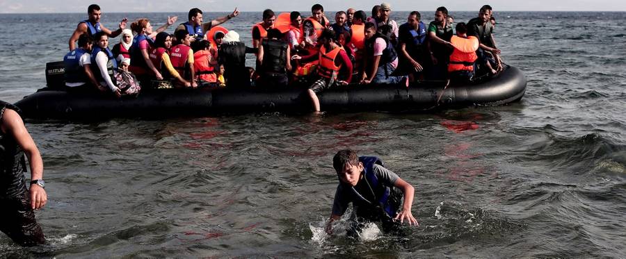 Refugees of Syria arrive on the shores of the Greek island of Lesbos aboard an inflatable dinghy across the Aegean Sea from Turkey on September 7, 2015. Greece sent troops and police reinforcements on September 6 to Lesbos after renewed clashes between police and migrants, the public broadcaster said, while Syrian refugees on the island were targeted with Molotov cocktail attacks. More than 230,000 people have landed on Greek shores this year and the numbers have soared in recent weeks as people seek to take advantage of the calm summer weather. 