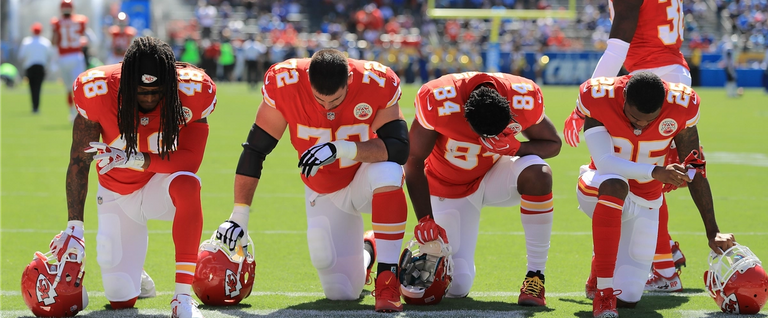 Terrance Smith #48, Eric Fisher #72, Demetrius Harris #84, and Cameron Erving #75 of the Kansas City Chiefs is seen taking a knee before the game against the Los Angeles Chargers at the StubHub Center on September 24, 2017 in Carson, California.
