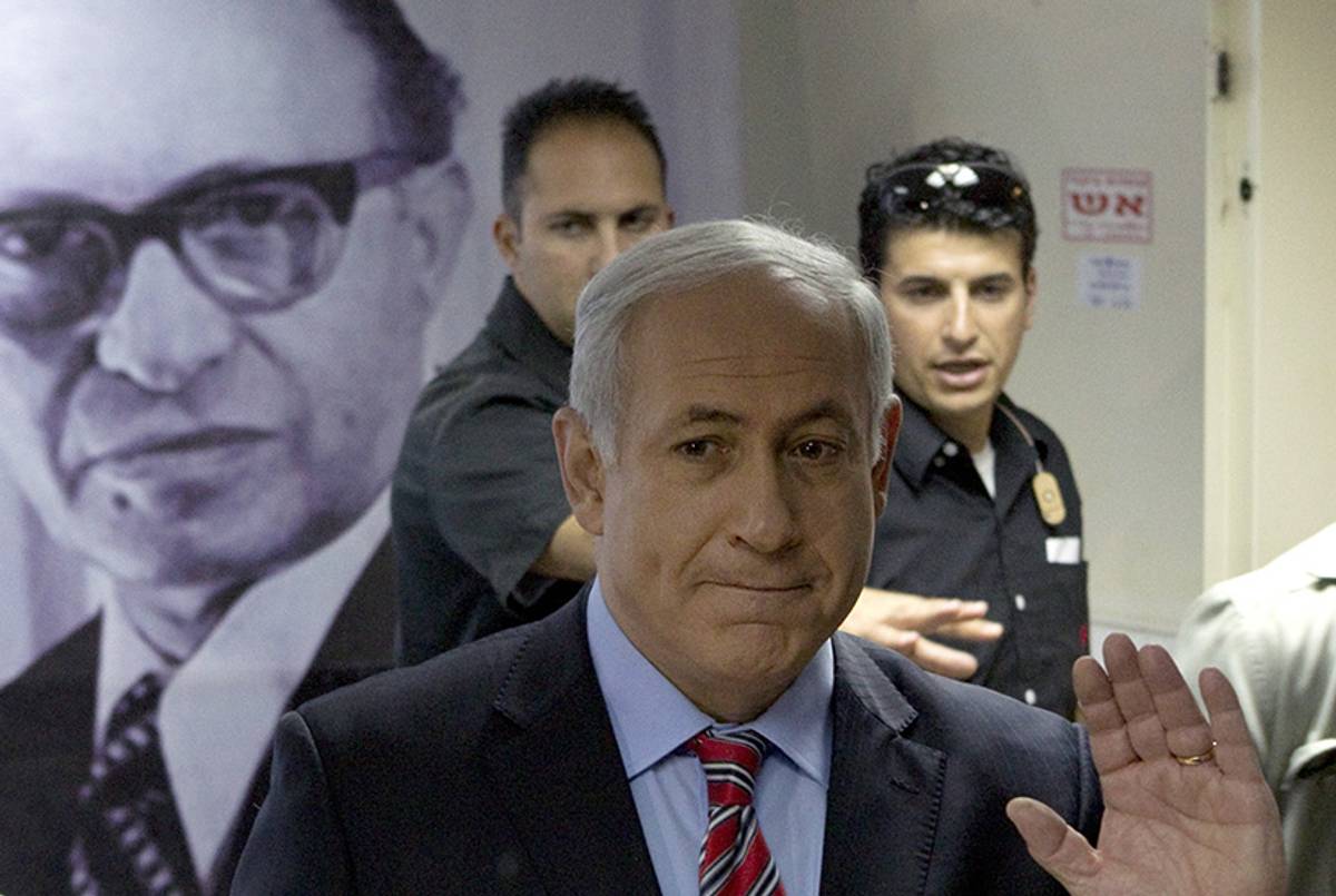 Benjamin Netanyahu waves near a portrait of Menachem Begin after casting his ballot for a proposal to amend the Likud party's constitution at the party's headquarters in Tel Aviv on April 29, 2010.(Jack Guez/AFP/Getty Images)