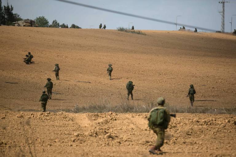 Israeli soldiers patrol as they search for Palestinian militants near Kibbutz Kfar Aza near the border with Gaza on Oct. 10, 2023