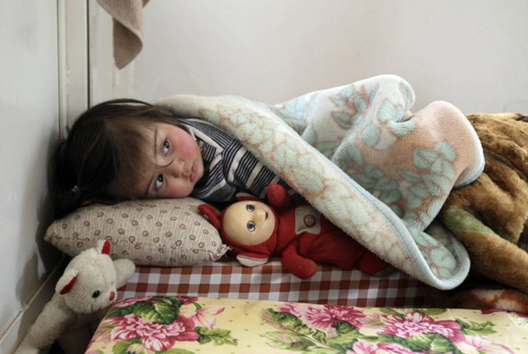 A Syrian girl who fled the violence in Syria sleeps with a doll at a shelter housing refugees in the Lebanese city of Arsal in the Bekaa Valley on March 26, 2012. (JOSEPH EID/AFP/Getty Images)