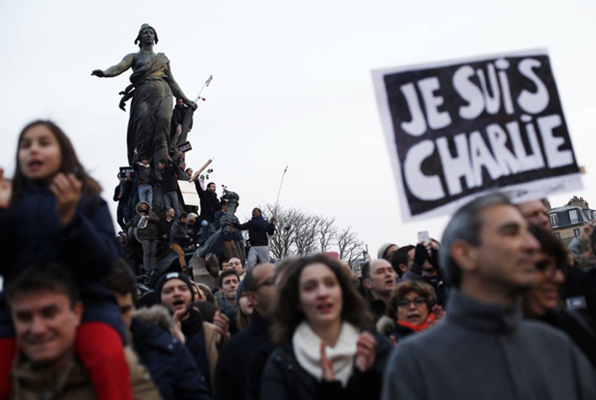 People holding cardboards reading 'Je suis Charlie' take part in a solidarity rally on the Place de la Nation in Paris on January 11, 2015. (THOMAS SAMSON/AFP/Getty Images)