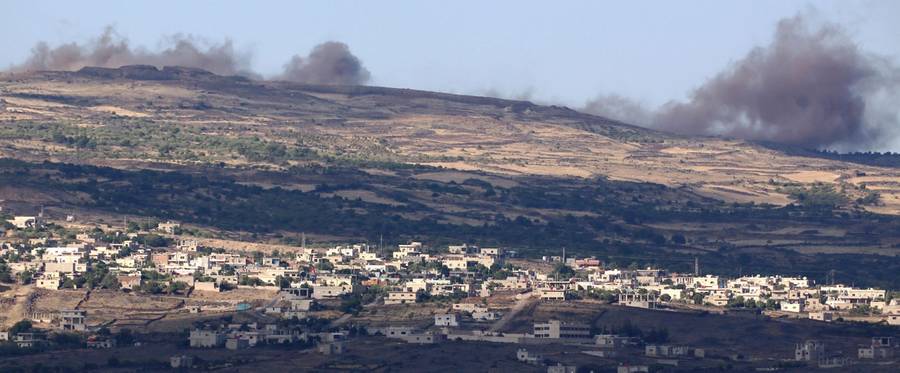 A picture taken from the Israeli-annexed Golan Heights shows smoke rising in the Syrian Druze village of Hadar on June 20, 2015, following Syrian army airstrikes against opposition rebel fighters. 