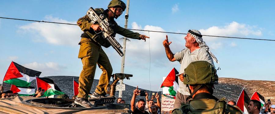 A Palestinian protester yells at an Israeli soldier as he confronts him atop an Israeli army vehicle during a protest against Israeli forces conducting an exercise in a residential area near the Palestinian village of Naqura, northwest of Nablus in the occupied West Bank, on Sept. 4, 2019