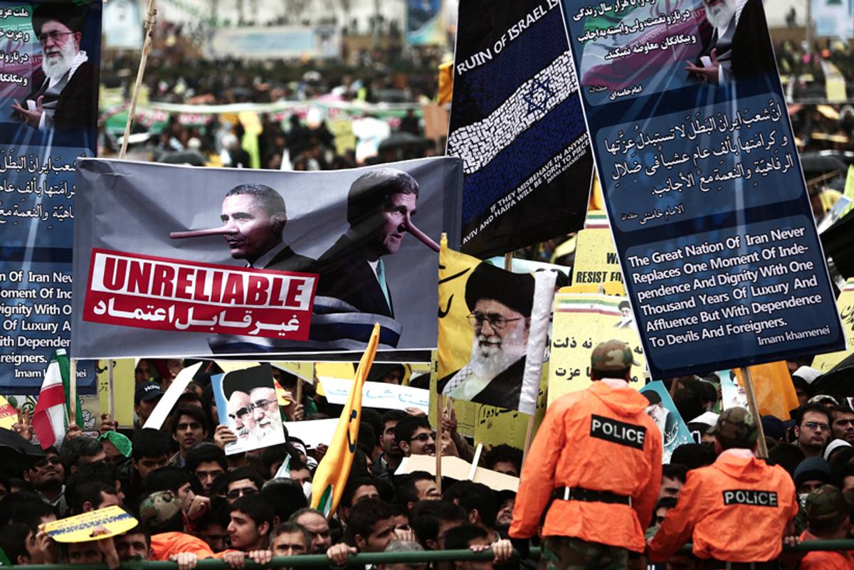 Iranian demonstrators hold a placard bearing portraits mocking U.S. President Barack Obama and Secretary of State John Kerry alongside anti-Israel slogans during a rally to mark the 36th anniversary of the Islamic revolution in Tehran's Azadi Square (Freedom Square) on Feb. 11, 2015.(Behrouz Mehri/AFP/Getty Images)