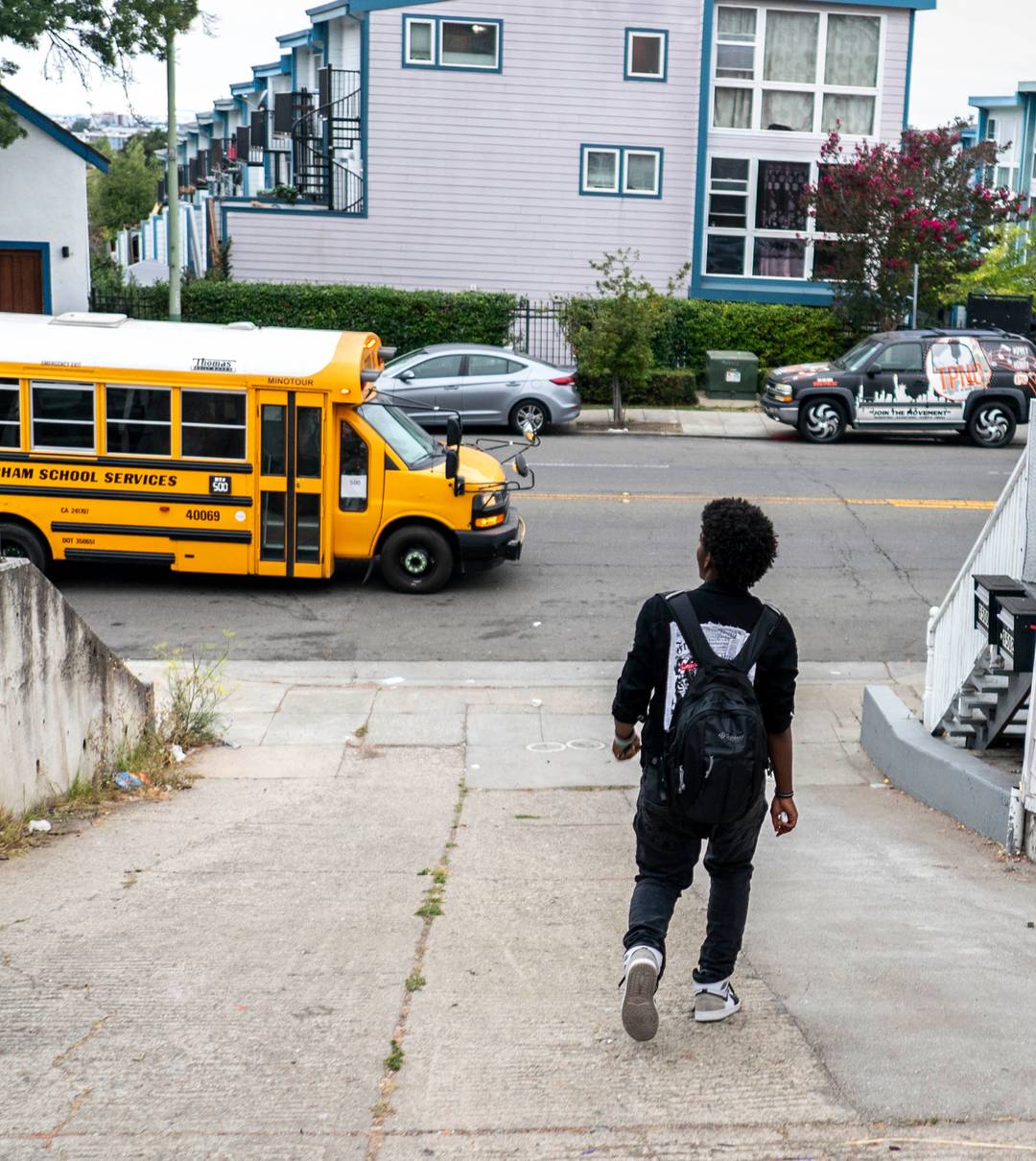 A boy walking to a catch a public bus to his high school in Oakland, California