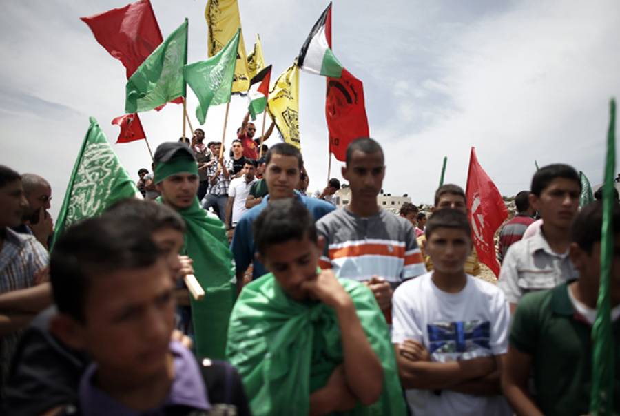 Palestinians wave flags as they attend the funeral procession of Musaab Nuwarah, 20, and and Mohammed Udeh, 17, a day after they were shot dead by Israeli forces during clashes outside the Israeli-run Ofer prison near the West Bank city of Ramallah on May 16, 2014. (THOMAS COEX/AFP/Getty Images)