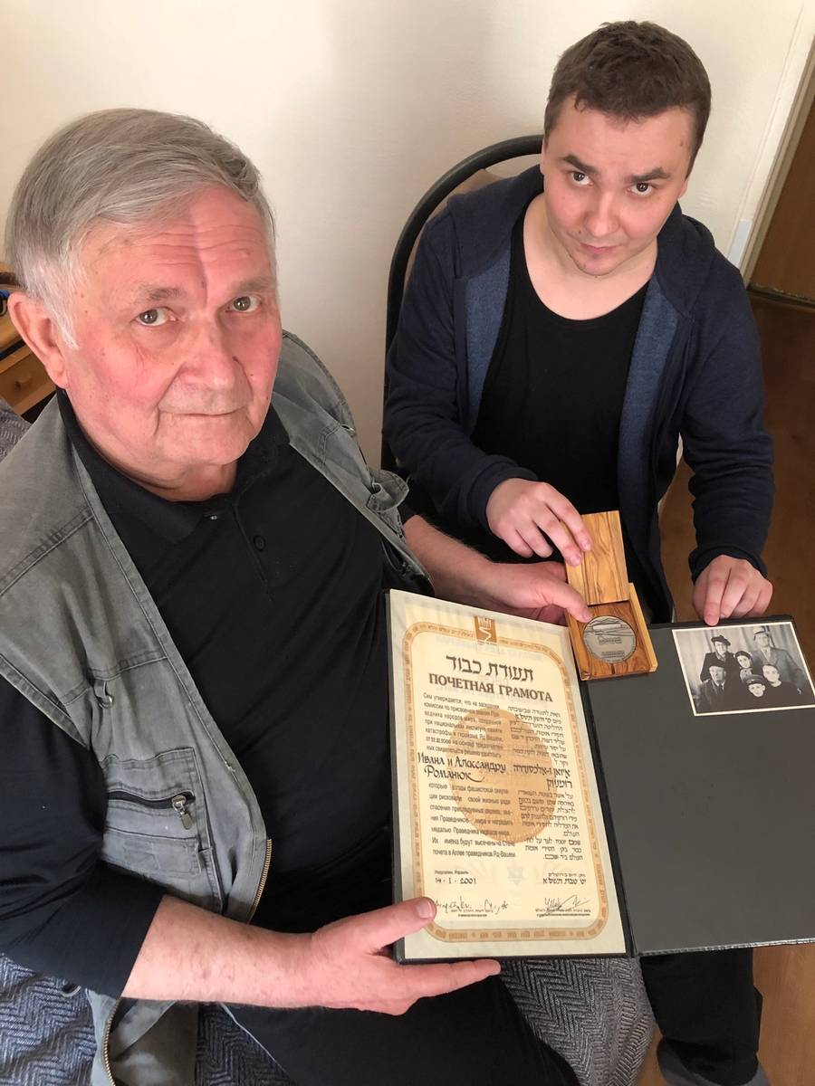 In their Jerusalem hotel room, Vladimir and son Sergey Kuklin displaying the certificate and medallion that Yad Vashem awarded in November 2000 to their ancestors, Ivan and Aleksandra Romaniuk