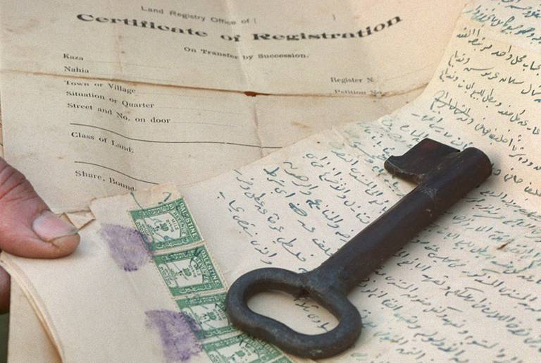 Mohammed Abu Yussef al-Affendi, a 67-year-old Palestinian refugee in the Dehaishe Refugee Camp, displays the original key and title deeds to the home his family abandoned when they fled their village of Deir Aban during the 1948 Israeli War of Independence.(David Silverman/Getty Images)