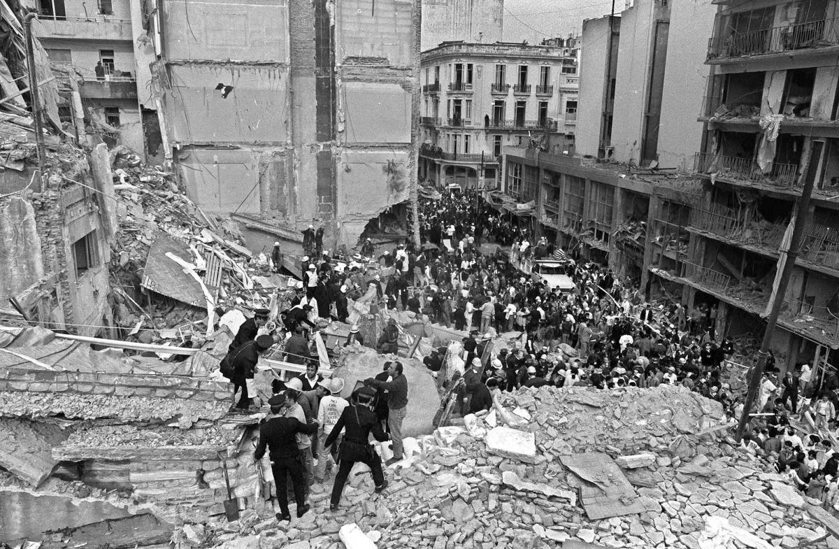 (FILE) Firemen and policemen search for wounded people after a bomb exploded at the Argentinian Israelite Mutual Association (AMIA in Spanish) in Buenos Aires, 18 July 1994. 85 people died in the attack. AFP PHOTO/Ali BURAFI (Photo by Ali BURAFI / AFP) (Photo by ALI BURAFI/AFP via Getty Images)