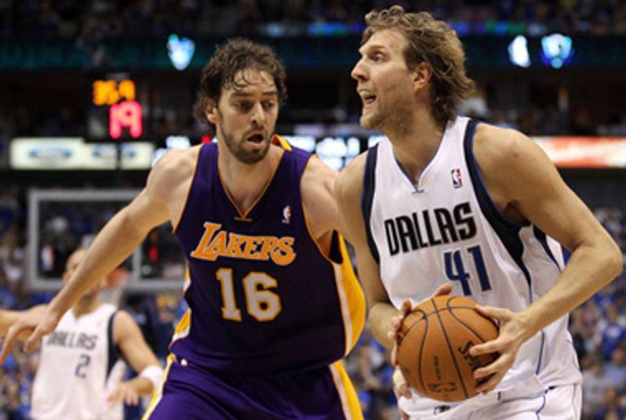 Dirk Nowitzki takes the rock yesterday as Pau Gasol looks helplessly on.(Photos by Ronald Martinez/Getty Images)