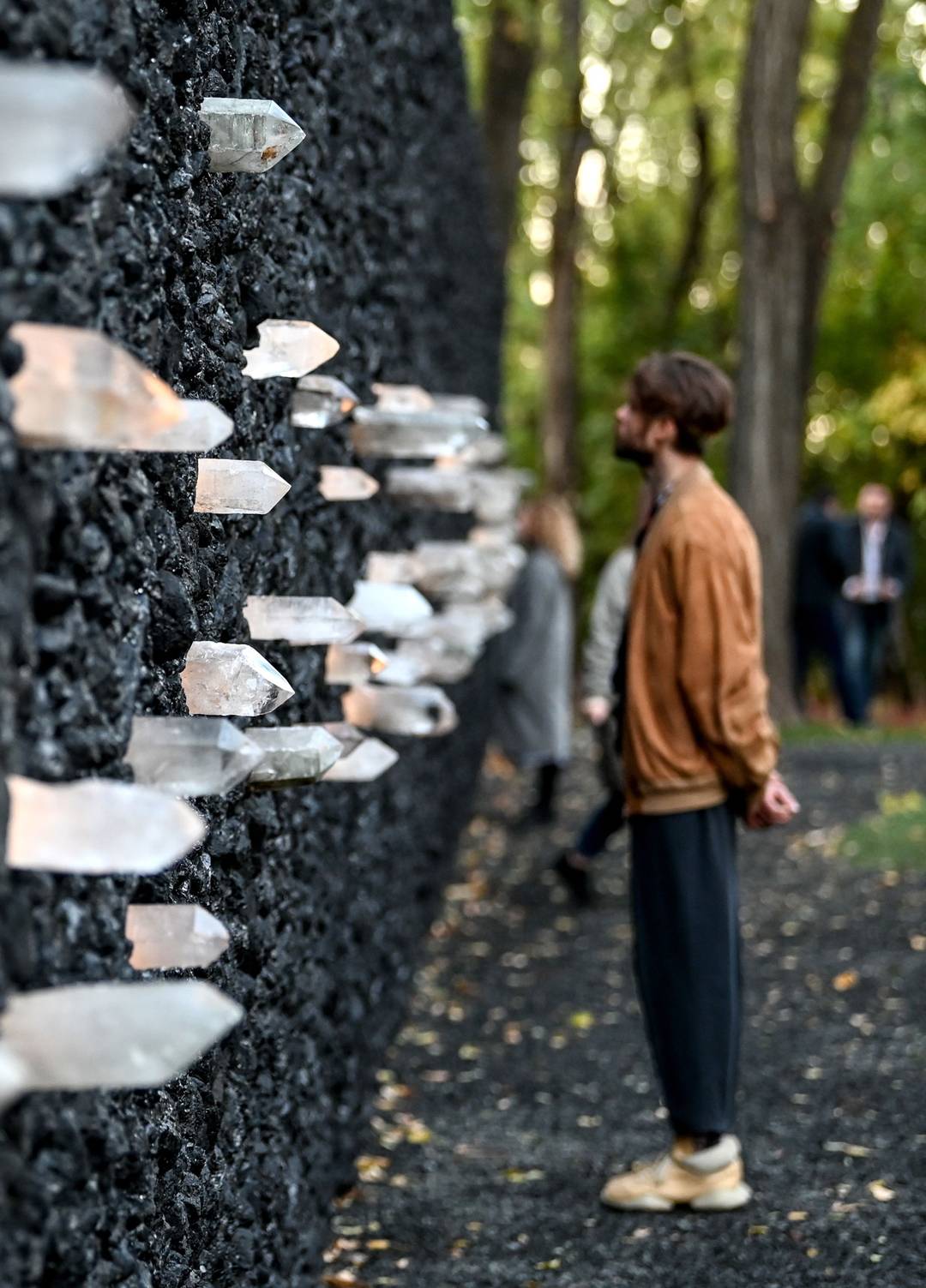 A man stands at the ‘Crystal Wall of Crying,’ at the Babyn Yar memorial, 2021