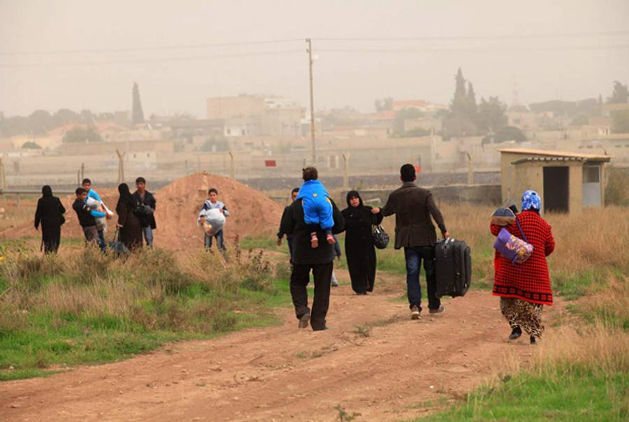 Syrians cross the border into Turkey on November 9, 2012 near the Turkish town of Ceylanpinar. Five Turks in Ceylanpinar, which lies across from Ras al-Ain, were lightly wounded on November 8, 2012 by ricocheting bullets from the Syrian side.(-/AFP/Getty Images)