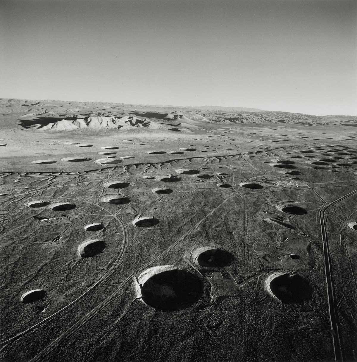 Emmet Gowin, SUBSIDENCE CRATERS, LOOKING SOUTHEAST FROM AREA 8, YUCCA FLAT, NEVADA TEST SITE, 1996. (From THE NEVADA TEST SITE by Emmet Gowin, with a foreword by Robert Adams, Princeton University Press, 2019.)