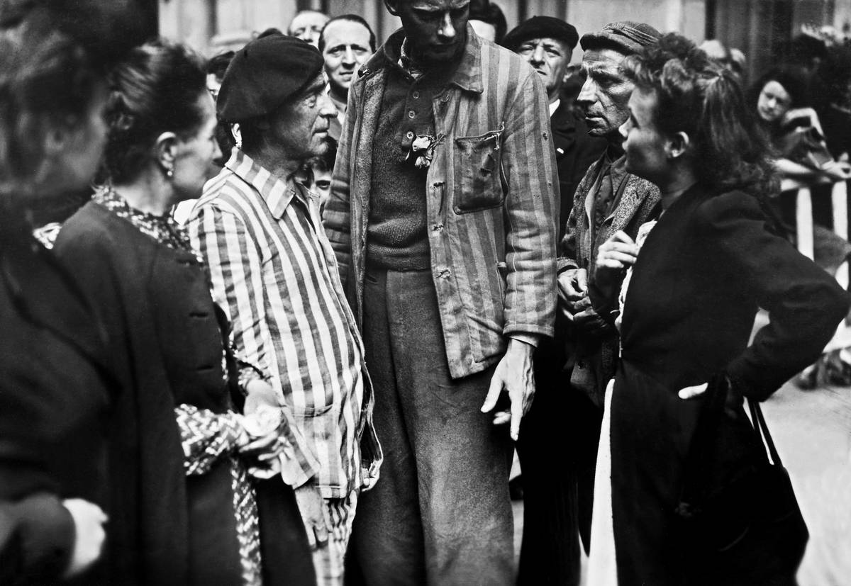 Deportees surrounded by inhabitants of Paris arrive at the Lutetia Hotel in 1945 after being released by Allied forces in occupied Germany