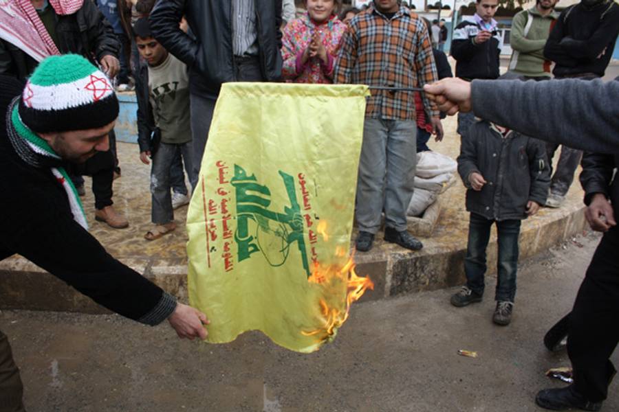 FSA supporters and opposition activists burn a Hezbollah flag, Bini'ish, Idleb province(AFP)