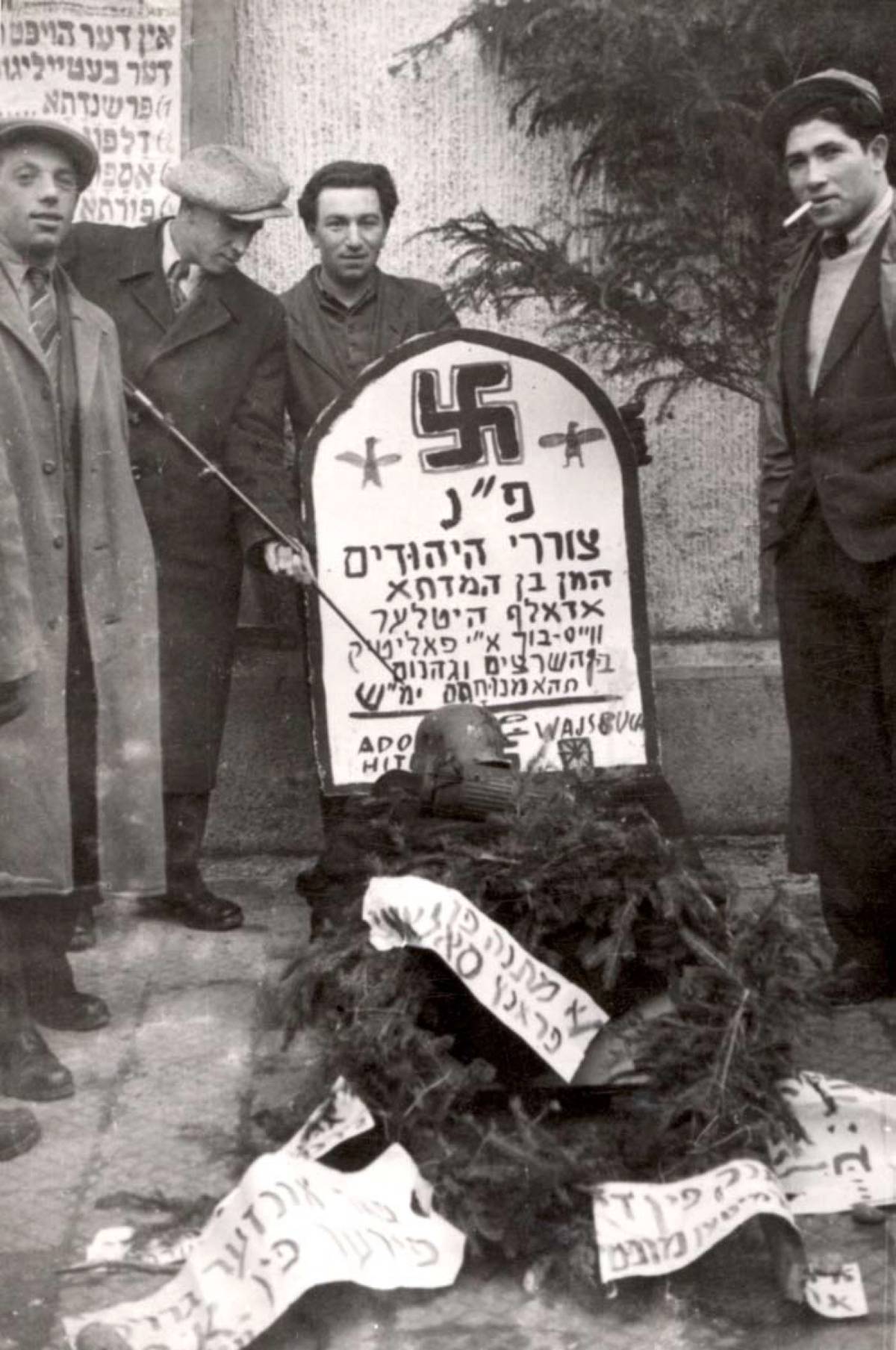 Celebrating Purim in the Landsberg DP camp. The tombstone reads, ‘Here is buried the oppressors of the Jews, Haman ben Hamdata, Adolf Hitler … among the insects and hell shall they find rest, may their names be erased.’