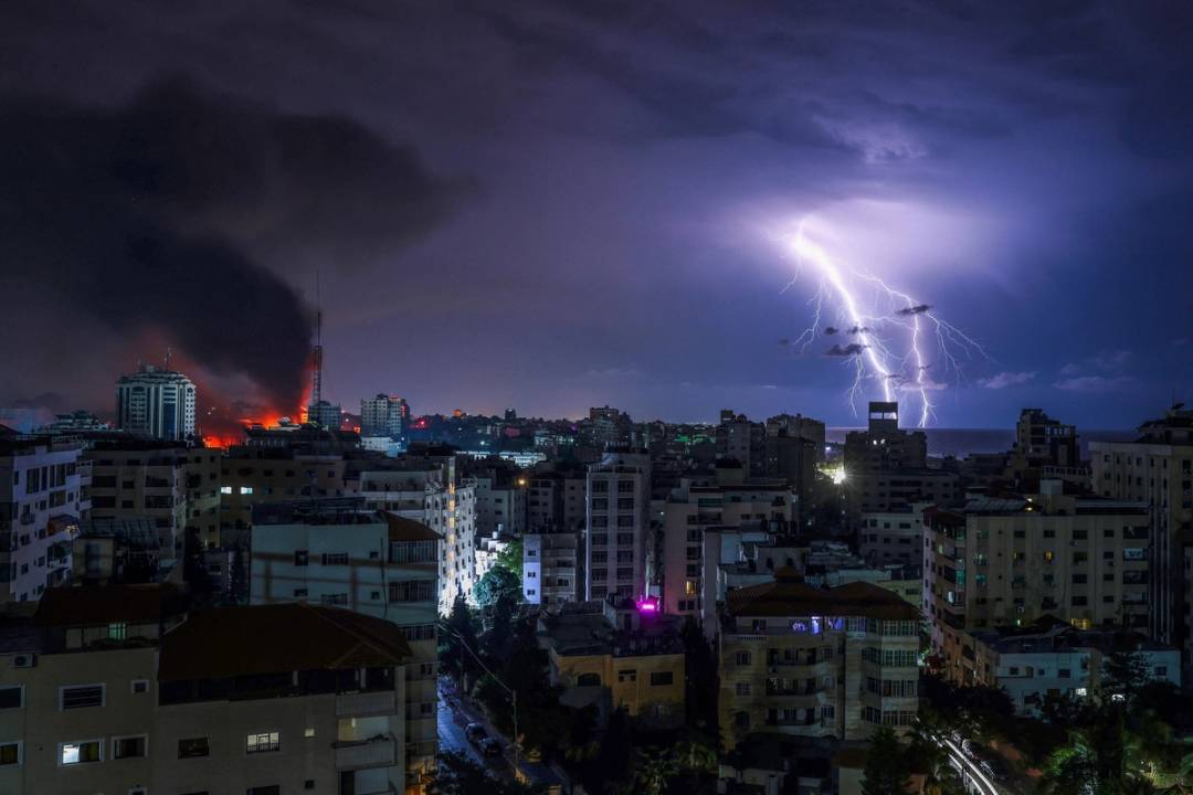 Lightning flashes as smoke billows following an Israeli airstrike in Gaza City on Oct. 9, 2023