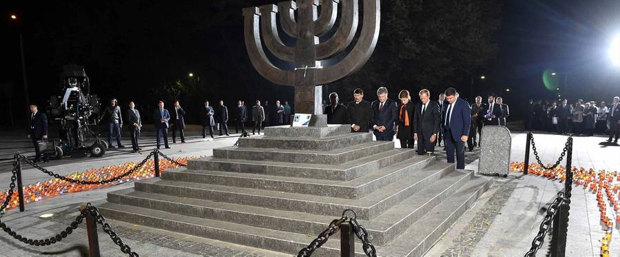 German President Joachim Gauck, Hungary's President Janos Ader, Ukrainian President Petro Poroshenko and his wife Maryna Poroshenko, European Council President Donald Tusk and Ukrainian Prime Minister Volodymyr Groysman pay tribute after placing candles at the Menorah-shaped memorial dedicated to the victims of the Babi Yar massacre during the commemoration ceremony on the 75th anniversary in Kiev on September 29, 2016.